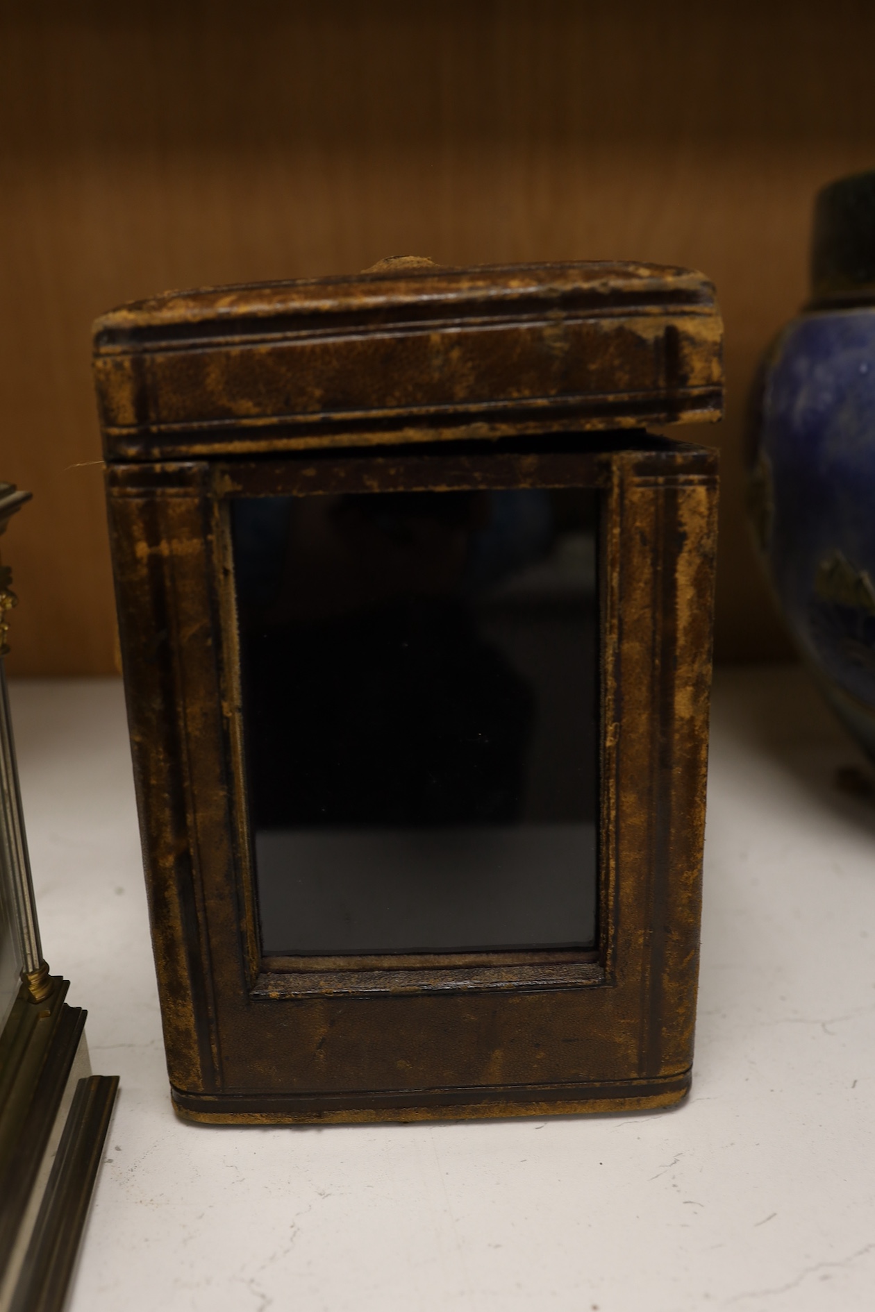 A carriage clock, in leather case, 18cm high. Condition - gilding worn and surface slightly pitted in places